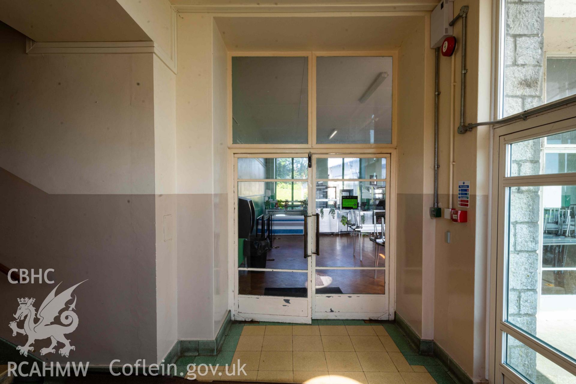 Glass doors to canteen at bottom of stairs connecting to reception foyer