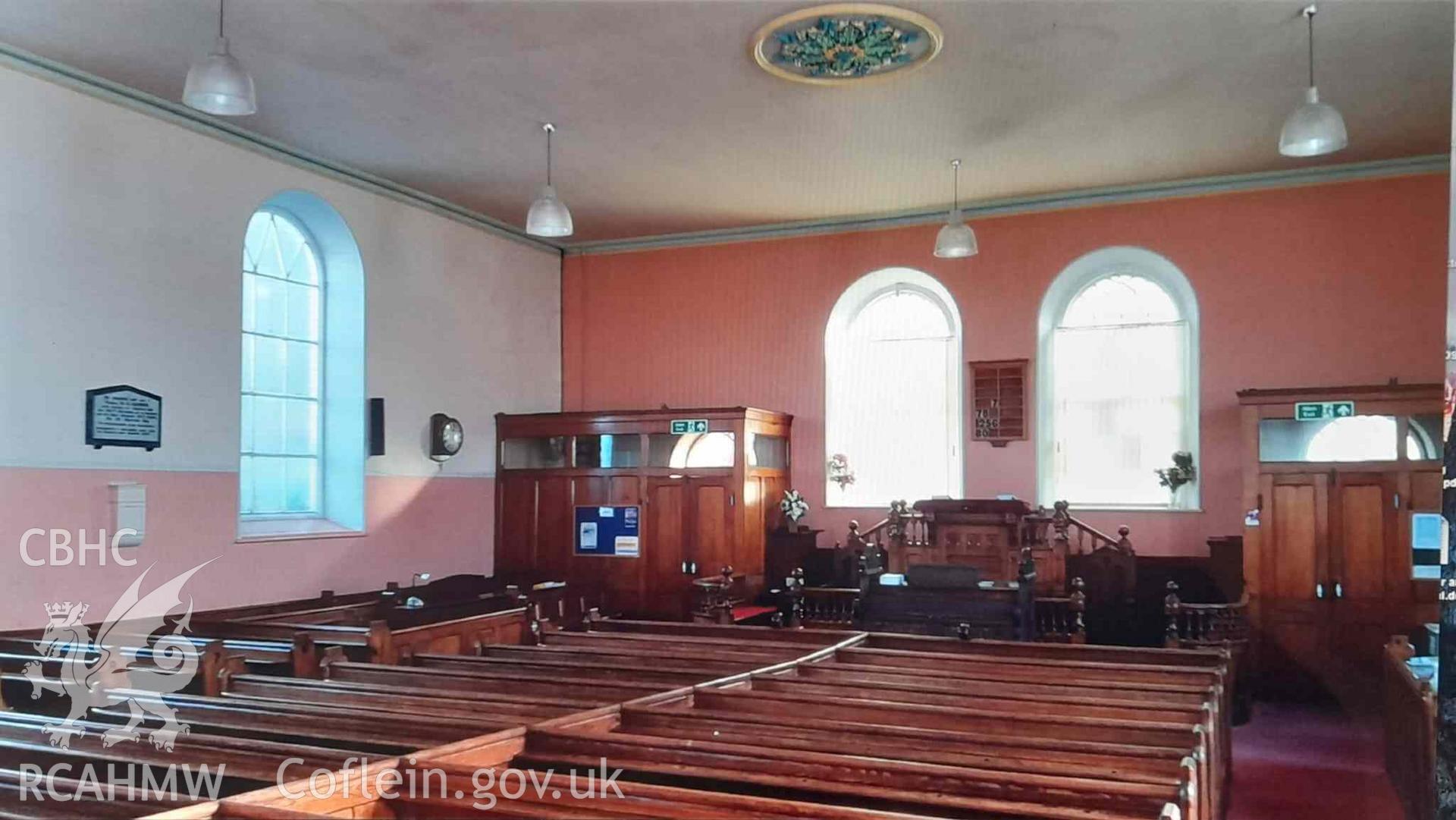 A digital photograph of Capel Saron, Llanbadarn Fawr, taken in 2019 before the chapel closed: interior, facing towards the front of the chapel and the pulpit.