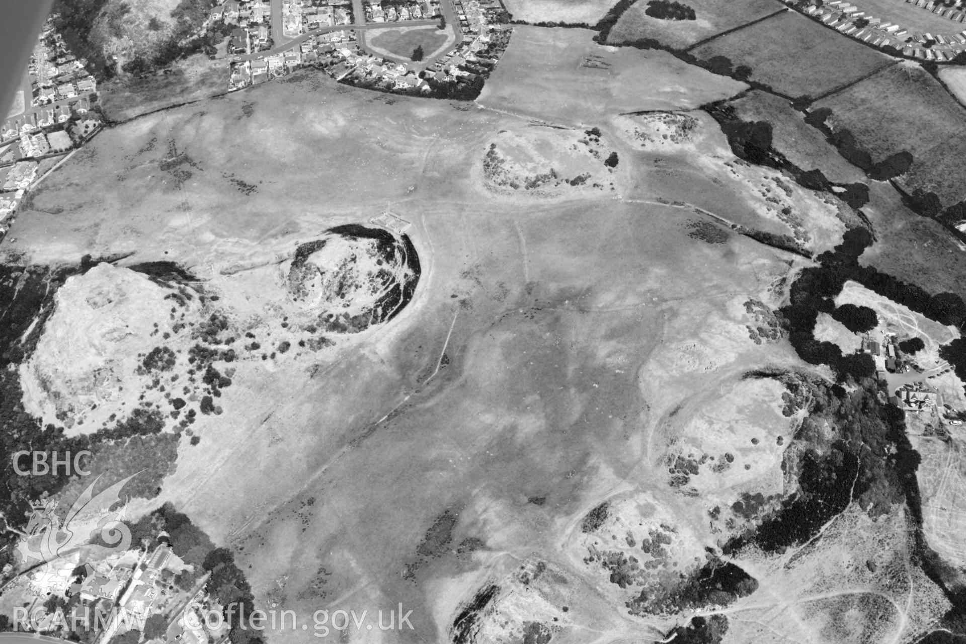 Oblique aerial photograph taken during the Royal Commission’s programme of archaeological aerial reconnaissance: Deganwy Castle - View with drought parching, with colour bands rebalanced to show archaeology