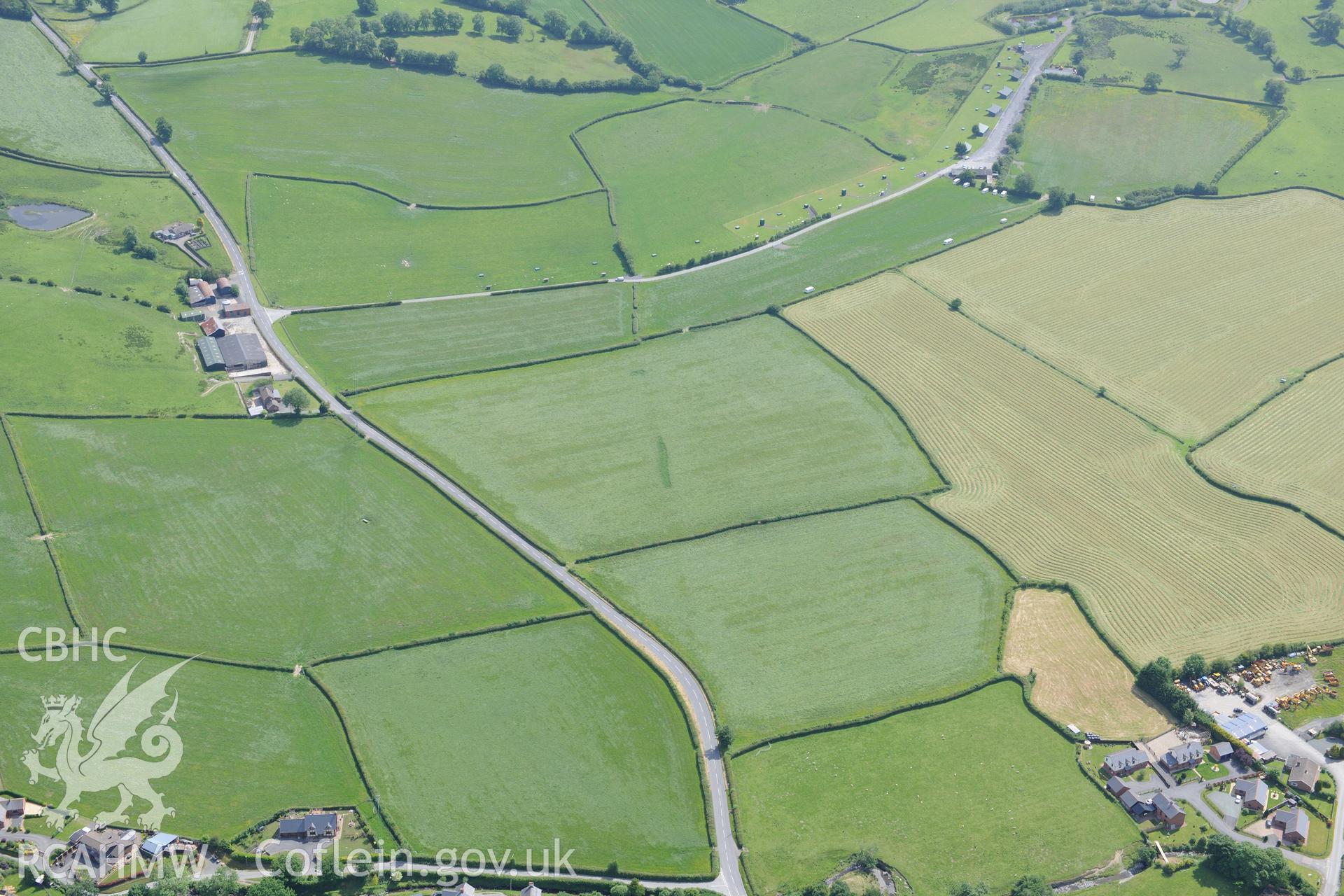 Oblique aerial photograph taken during the Royal Commission’s programme of archaeological aerial reconnaissance: Roman road between Penrhos and Trefeglwys-View with emerging cropmarks