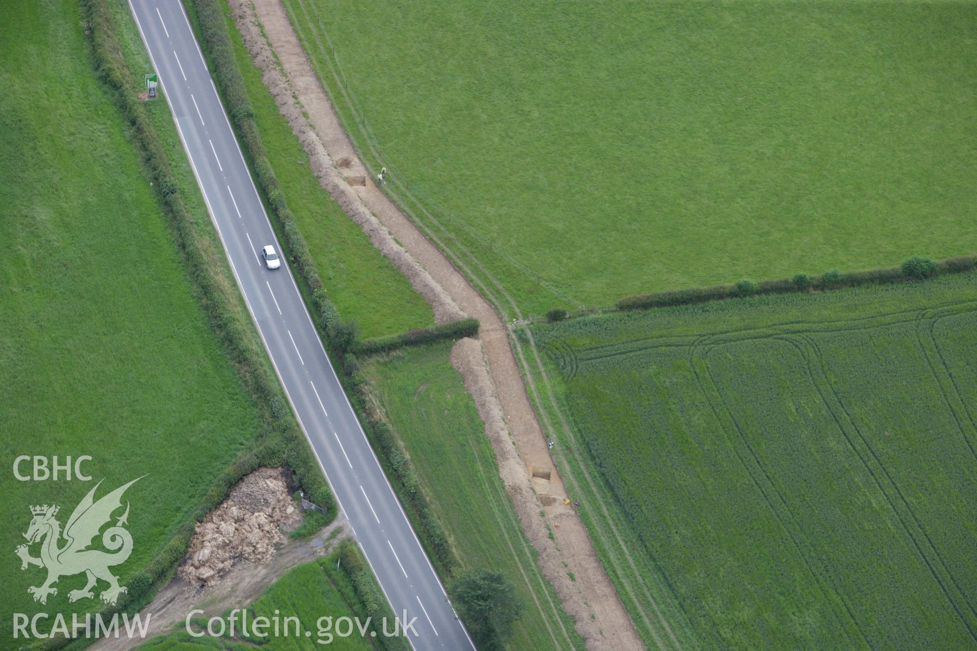 RCAHMW colour oblique aerial photograph of Lower Luggy Cursus, Dyffryn Lane, showing Clwyd-Powys Archaeological Trust excavations. Taken on 08 July 2009 by Toby Driver