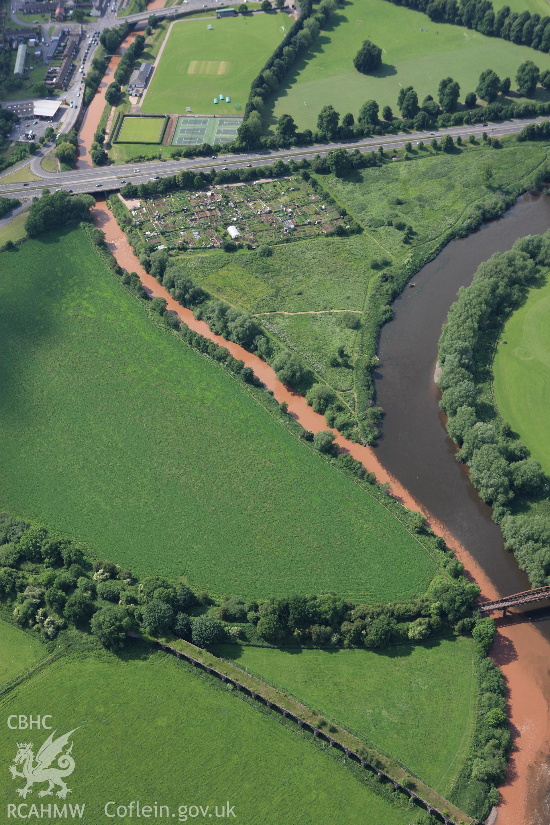 RCAHMW colour oblique aerial photograph of river patterns close to the Wye Bridge on the Hereford, Ross and Gloucester Railway in Monmouth. Taken on 11 June 2009 by Toby Driver