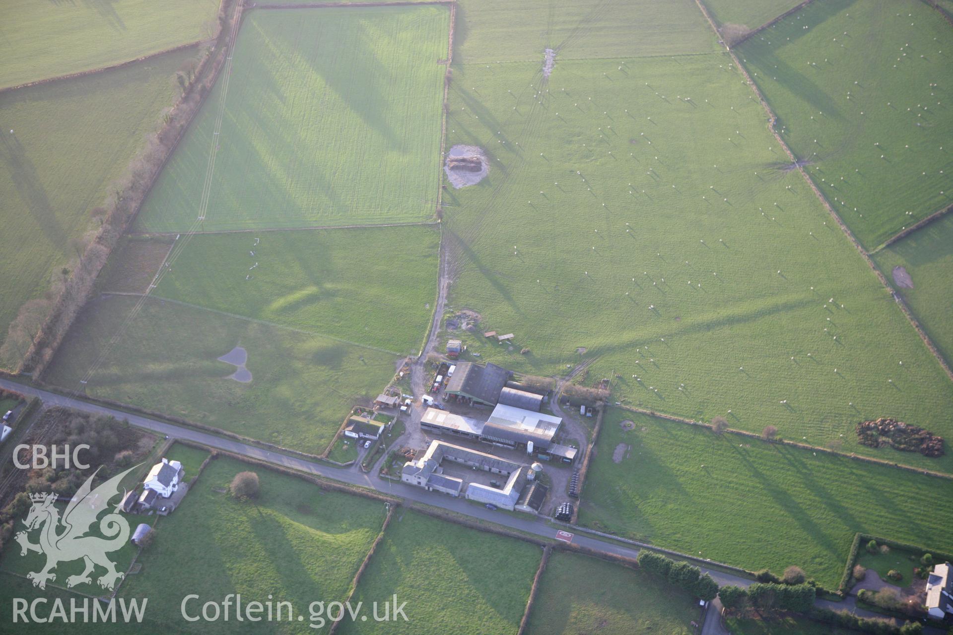 RCAHMW colour oblique aerial photograph of a circle, barrow and linear earthworks at Holywell. Taken on 10 December 2009 by Toby Driver