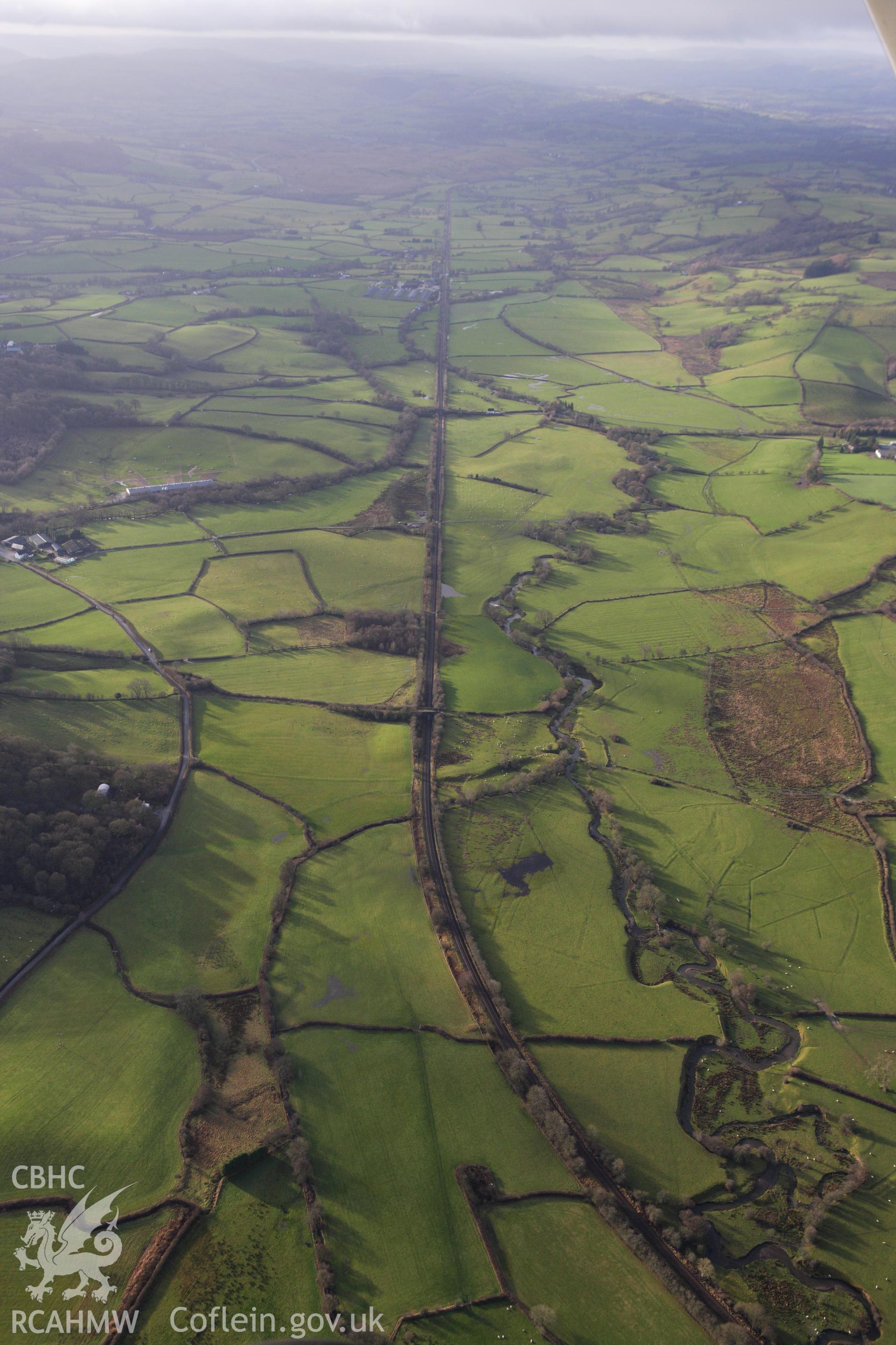RCAHMW colour oblique aerial photograph of landscape to south-west of Llanbister Road Railway Station, on the Heart of Wales line. Taken on 10 December 2009 by Toby Driver