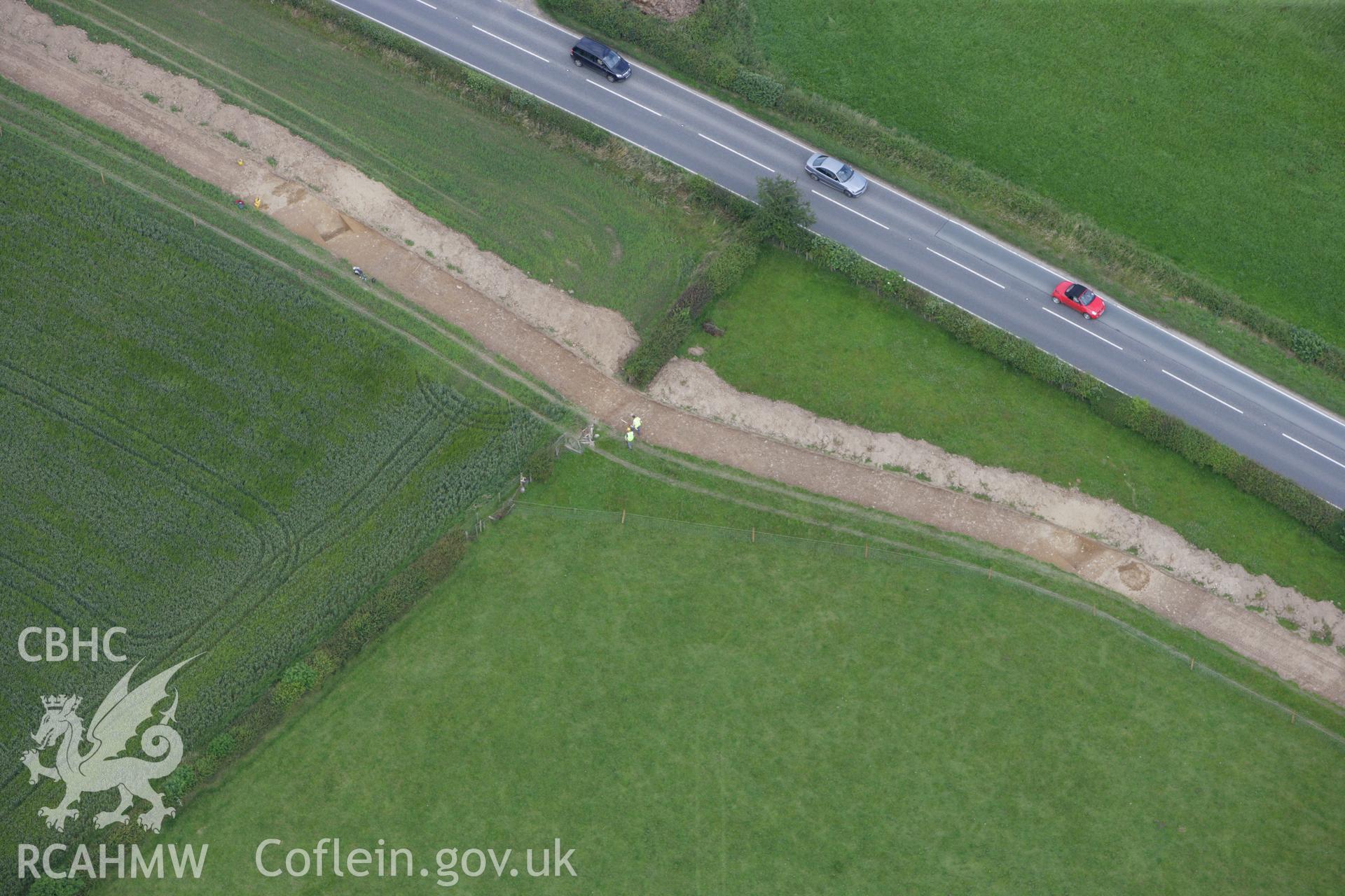 RCAHMW colour oblique aerial photograph of Lower Luggy Cursus, Dyffryn Lane, showing Clwyd-Powys Archaeological Trust excavations. Taken on 08 July 2009 by Toby Driver