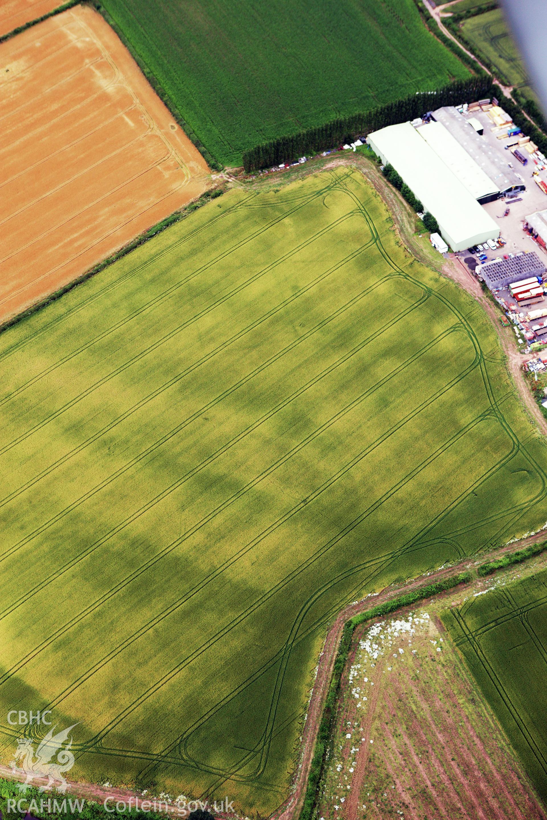 RCAHMW colour oblique aerial photograph of Llancayo Farm Defended Enclosure. Taken on 09 July 2009 by Toby Driver