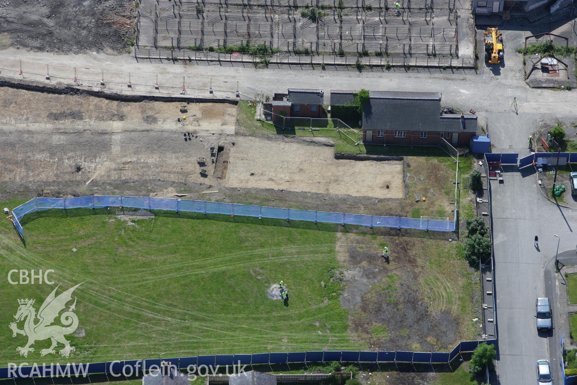 RCAHMW colour oblique aerial photograph of the Roman road in a field adjacent to the Smithfield Market in Newtown showing excavations by the Clwyd-Powys Archaeological Trust on the Tescos site. Taken on 02 June 2009 by Toby Driver