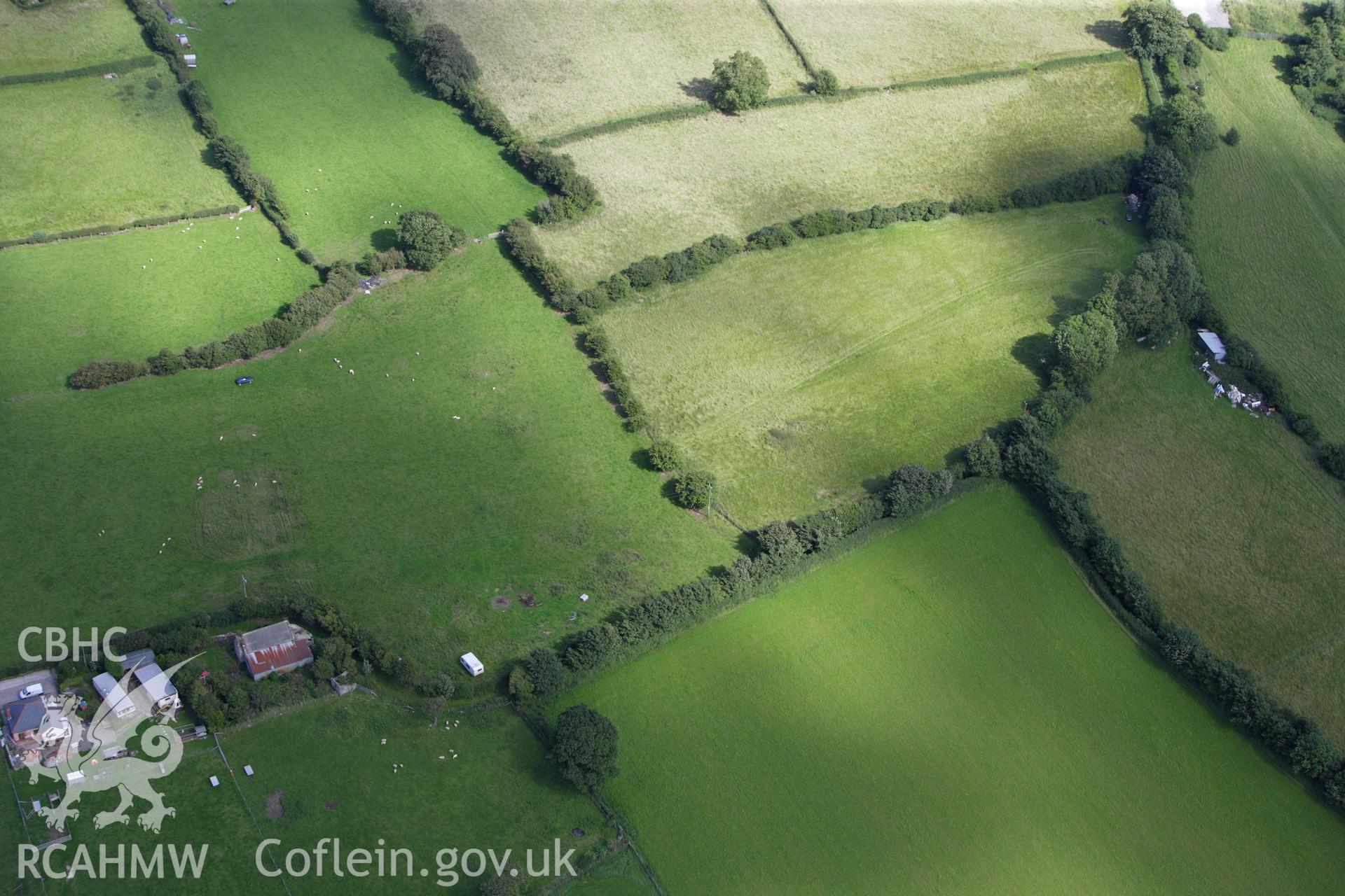 RCAHMW colour oblique aerial photograph of round barrow at Hen Dy. Taken on 30 July 2009 by Toby Driver