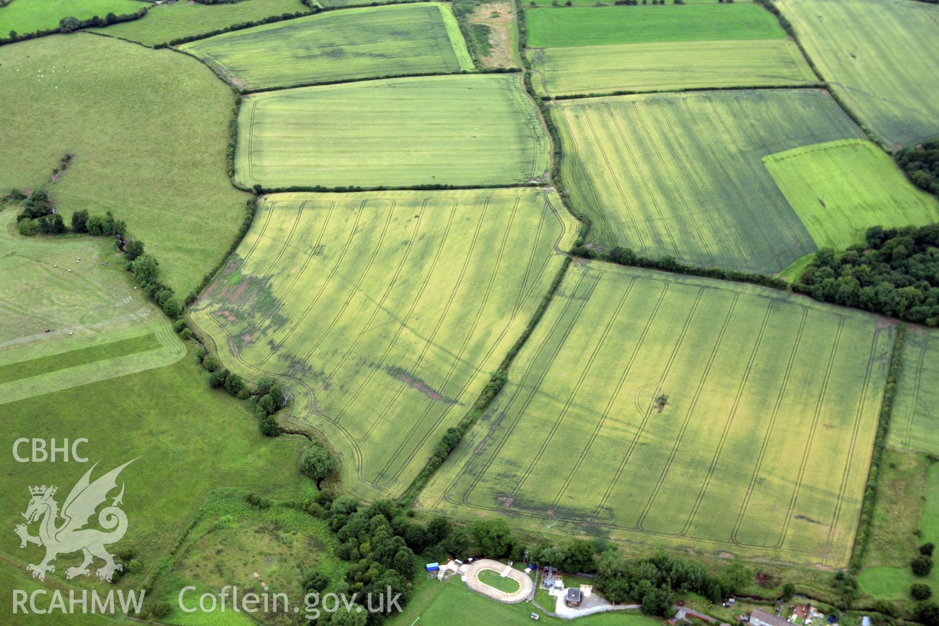 RCAHMW colour oblique aerial photograph of Monks Ditch showing cropmarks of strip field systems. Taken on 09 July 2009 by Toby Driver