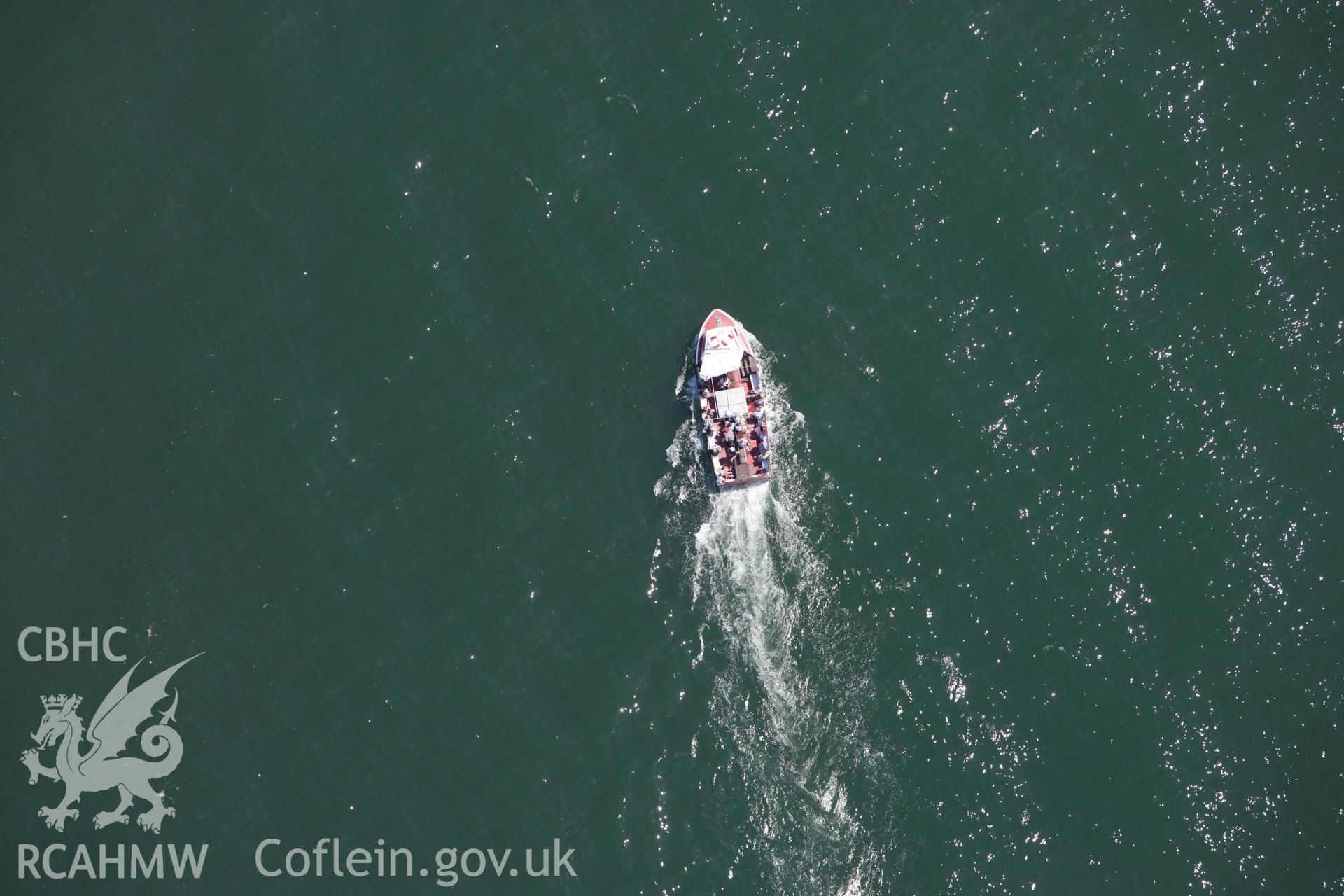RCAHMW colour oblique aerial photograph of New Quay, showing offshore pleasure boat. Taken on 01 June 2009 by Toby Driver