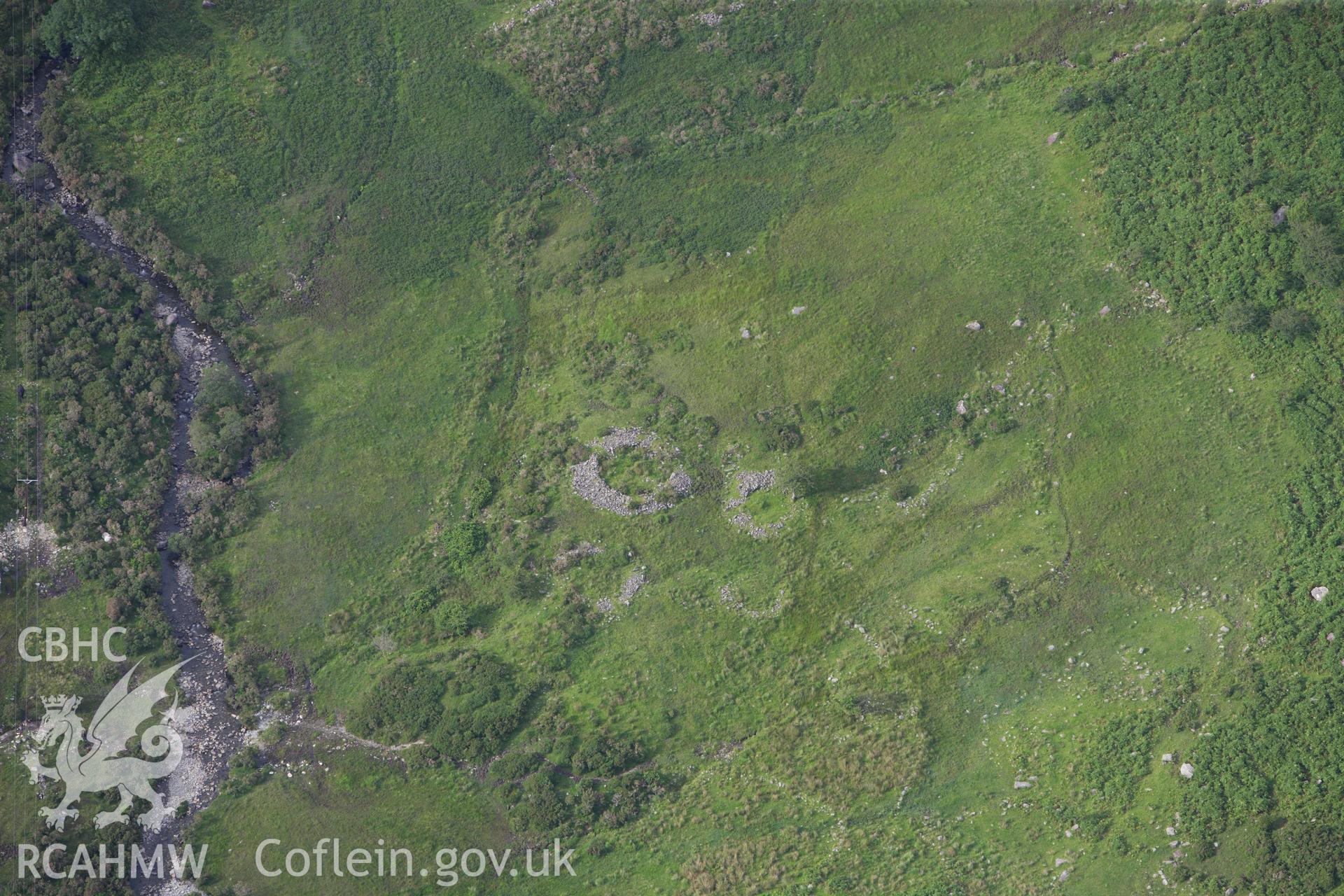 RCAHMW colour oblique aerial photograph of a hut circle settlement north of Cwm Dyli Power Station. Taken on 06 August 2009 by Toby Driver
