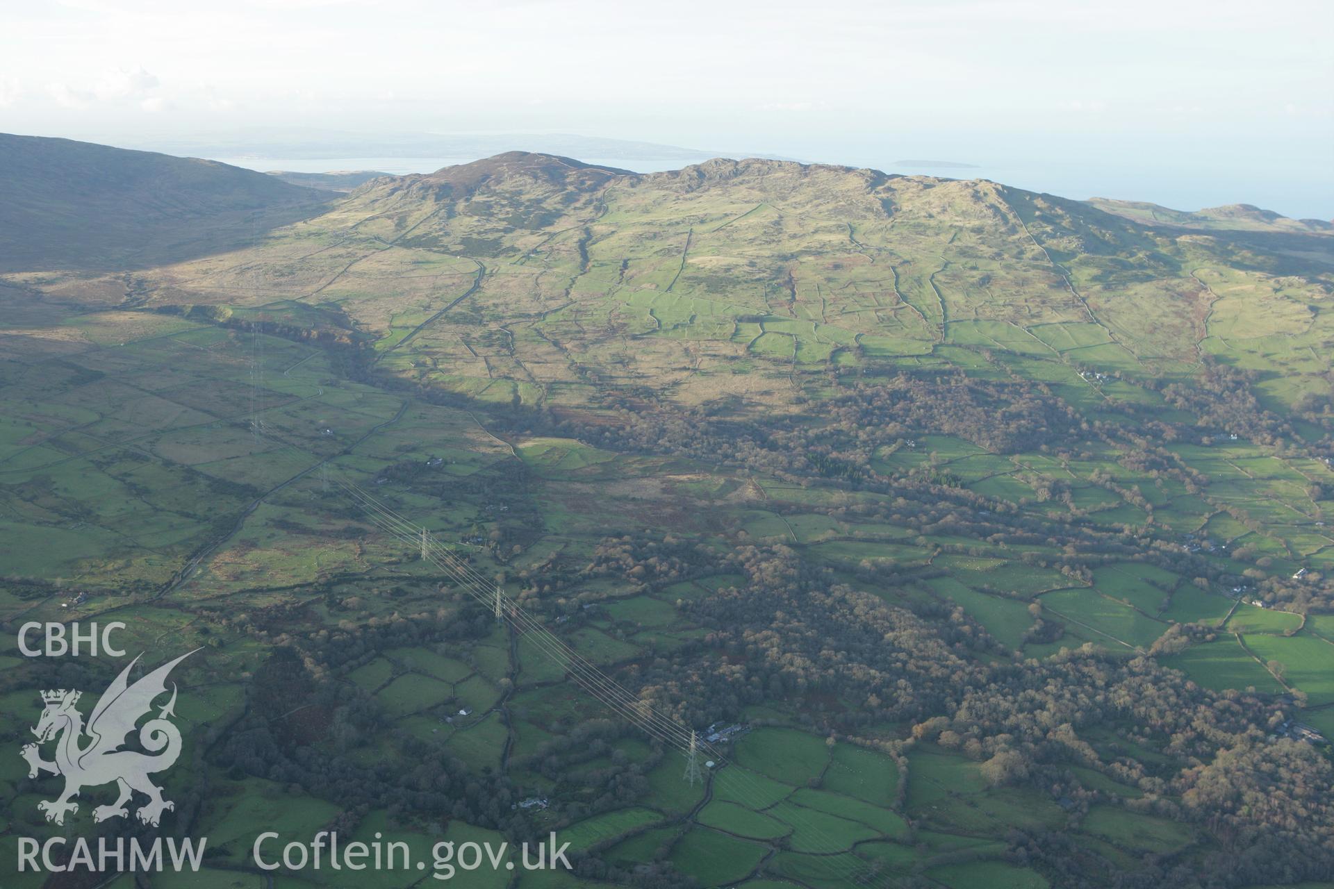RCAHMW colour oblique aerial photograph of Maen-y-Bardd Settlement and field systems, in landscape from south-east Taken on 10 December 2009 by Toby Driver