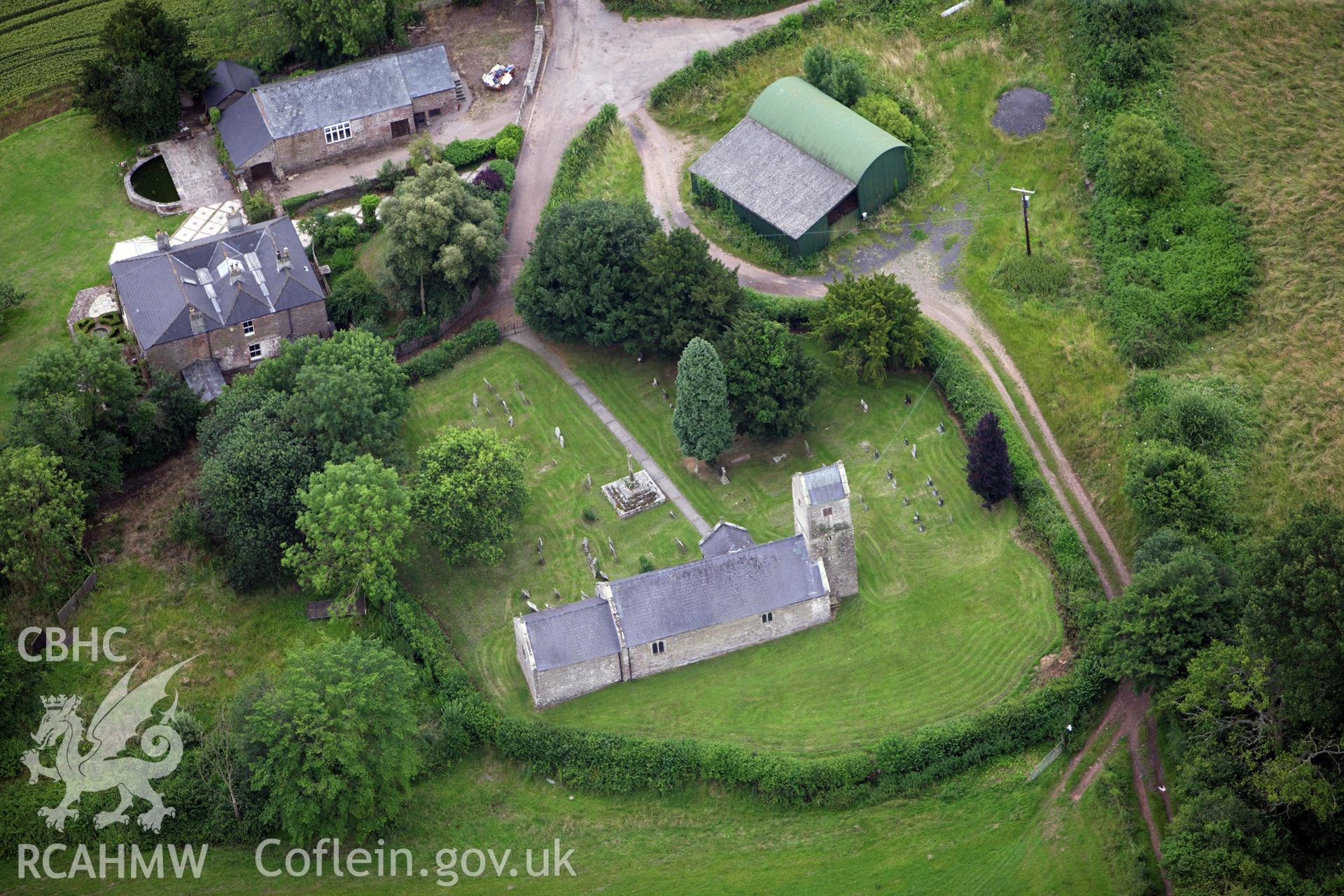 RCAHMW colour oblique aerial photograph of St Thomas a Becket, Wolvesnewton, showing the churchyard cross. Taken on 09 July 2009 by Toby Driver