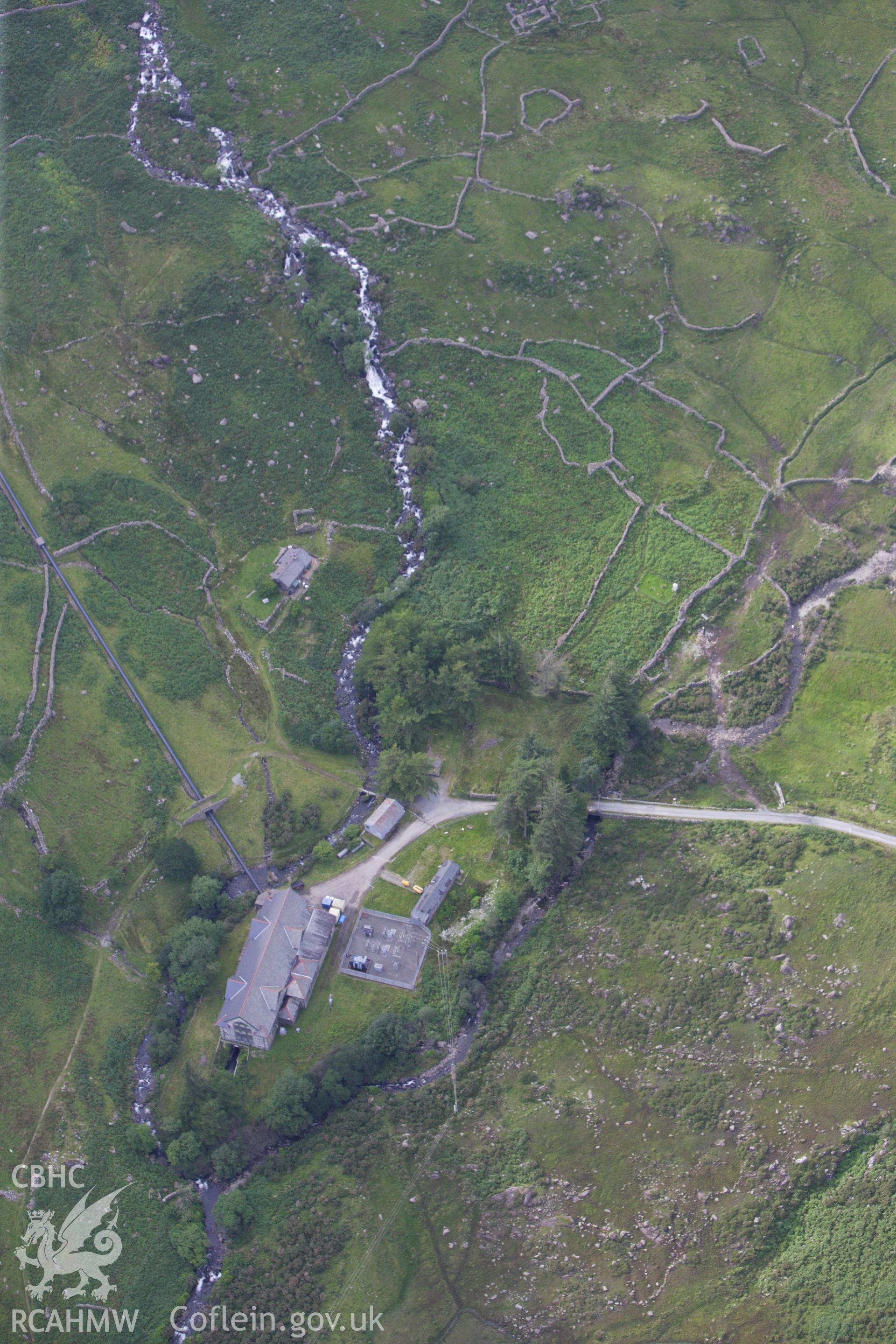 RCAHMW colour oblique aerial photograph of a hut circle settlement north of Cwm Dyli Power Station. Taken on 06 August 2009 by Toby Driver