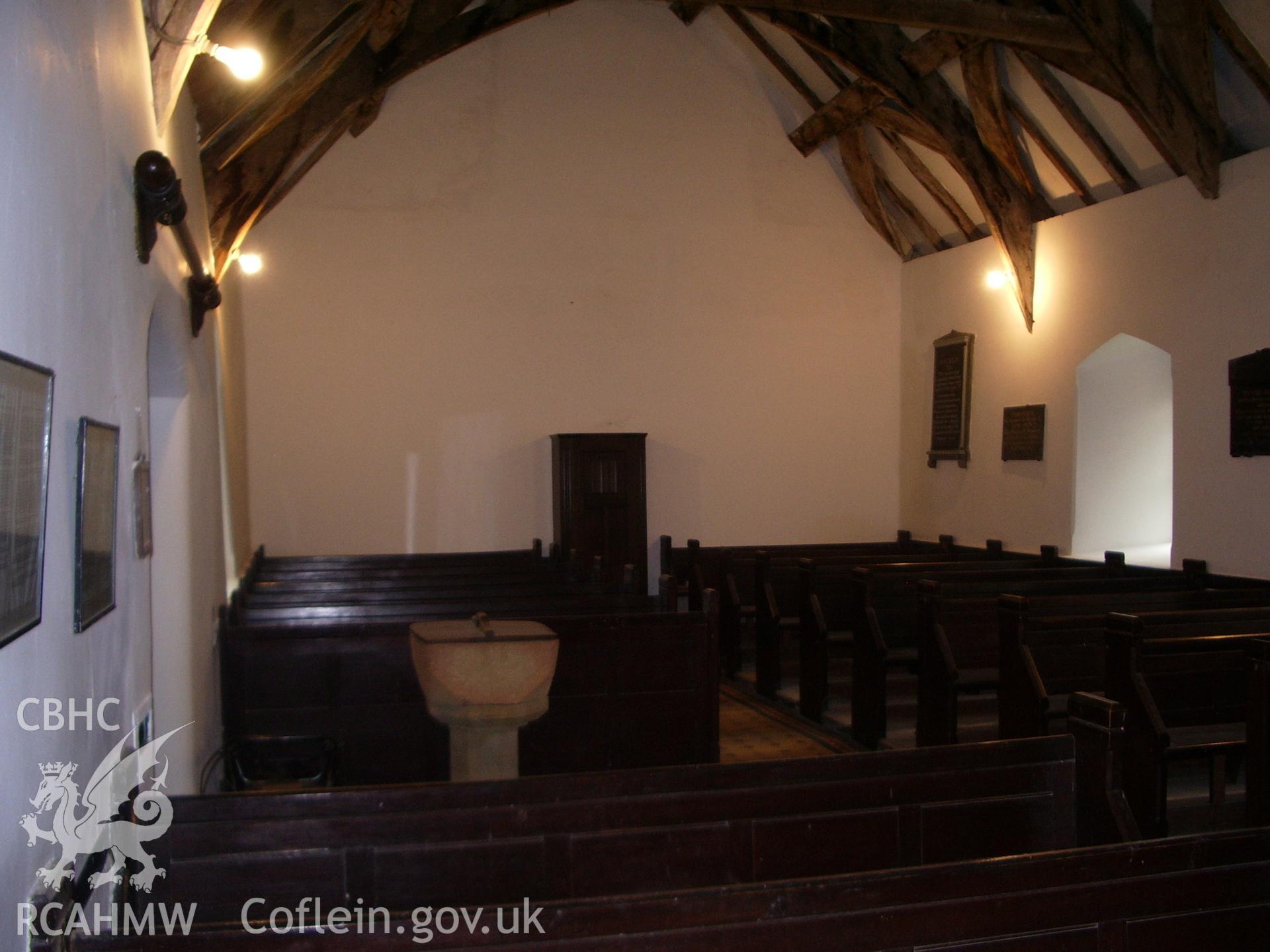 Interior view of the church looking west, showing the pews and the font.
