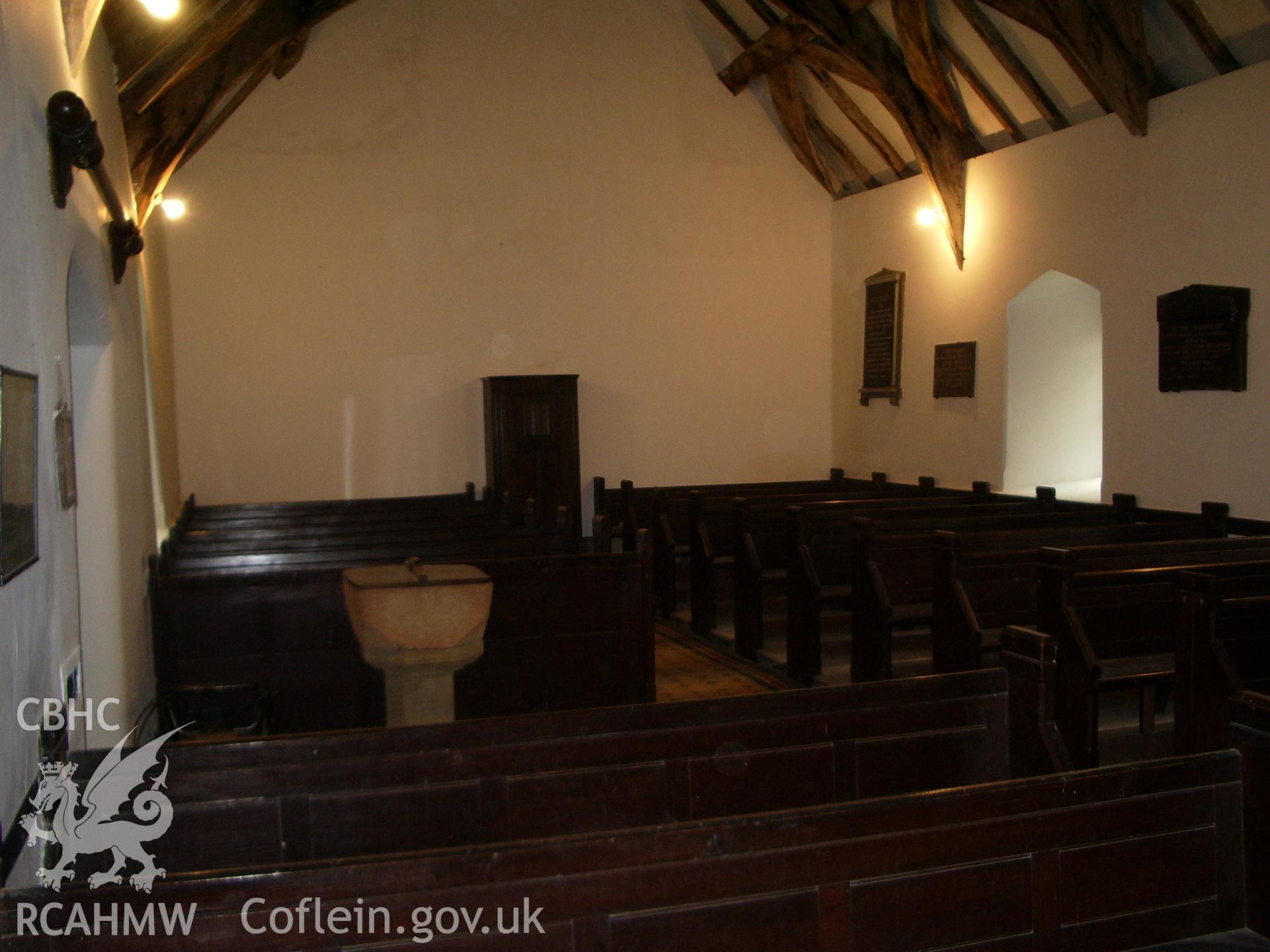Interior view of the church looking west, showing the pews and the font.