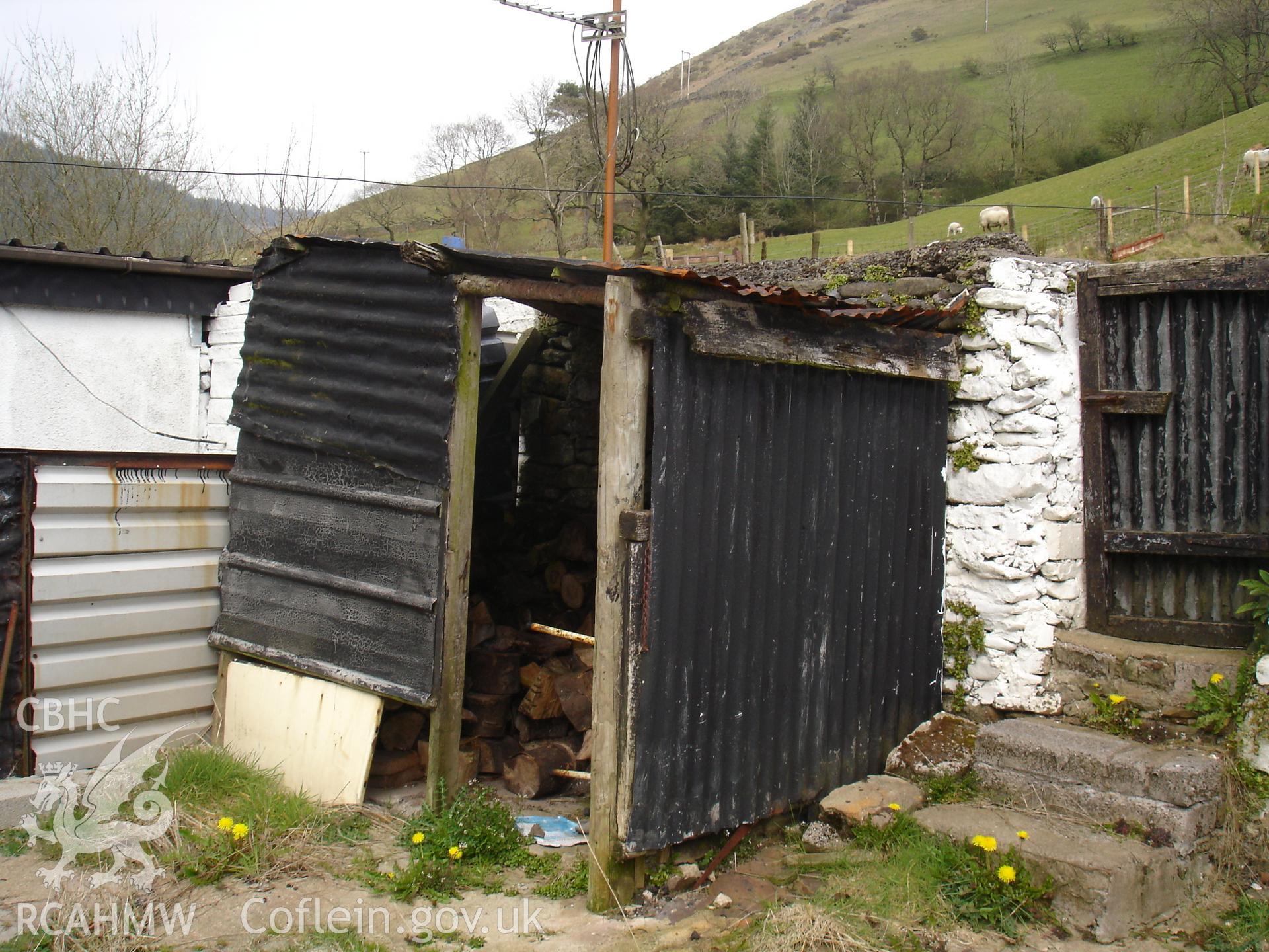 Colour digital photograph showing exterior view (woodshed and rear entrance) of a cottage at Gelli Houses, Cymmer.